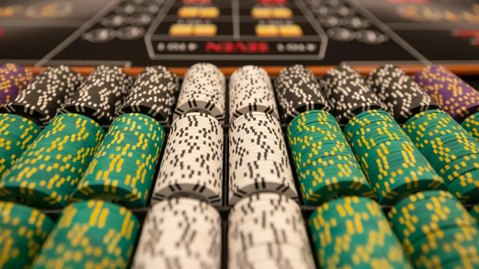 Tightly packed rows of stacked green and white casino chips