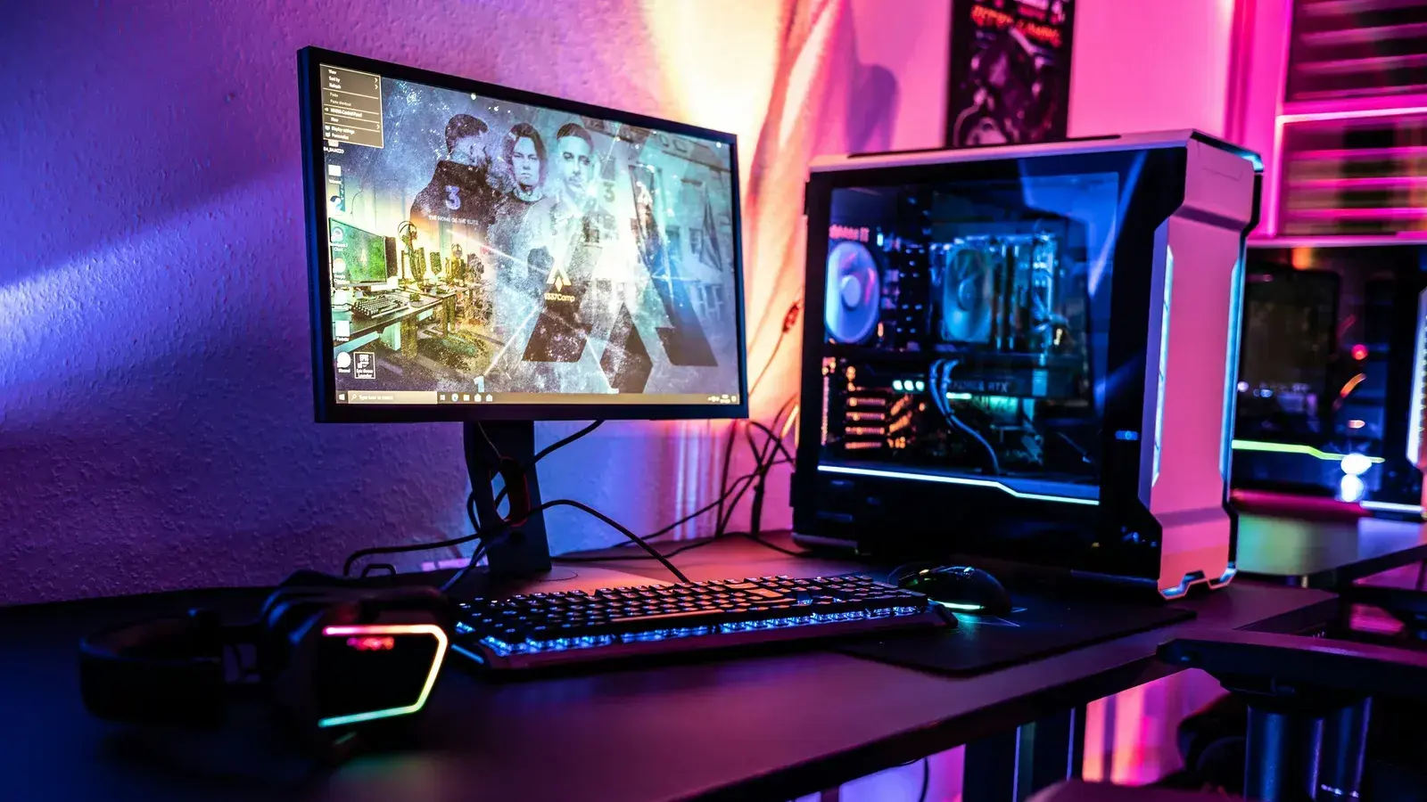 Two monitors and a pink-lit PC standing on a desk
