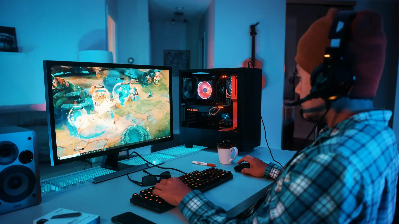 Man in a checked shirt playing a game at a desk