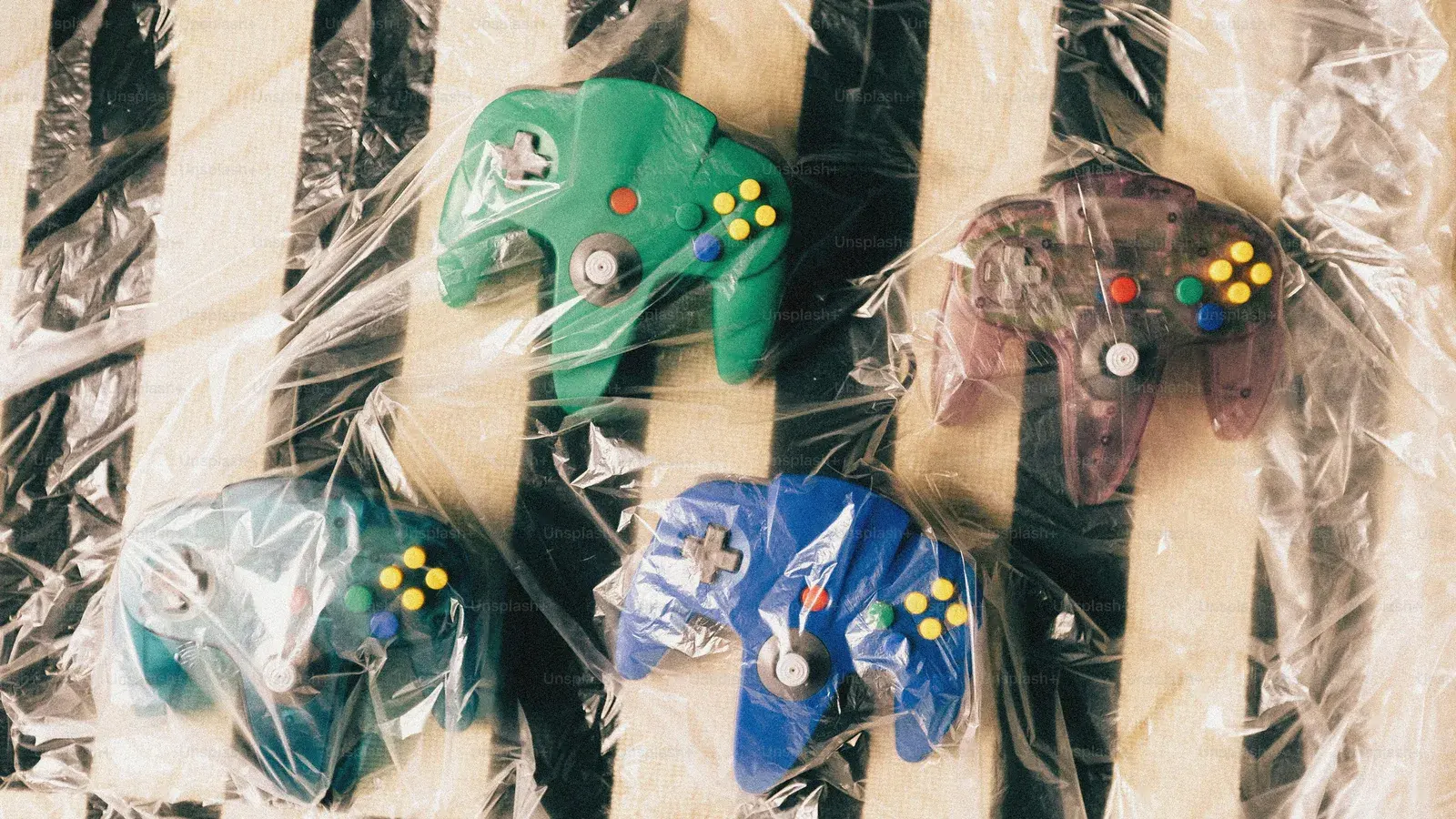 Nintendo 64 controllers in packaging, green and purple