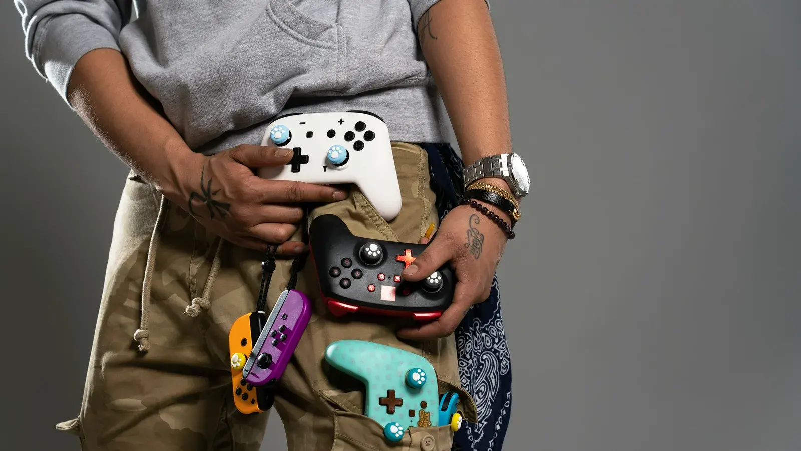Person holding four game controllers against their waist