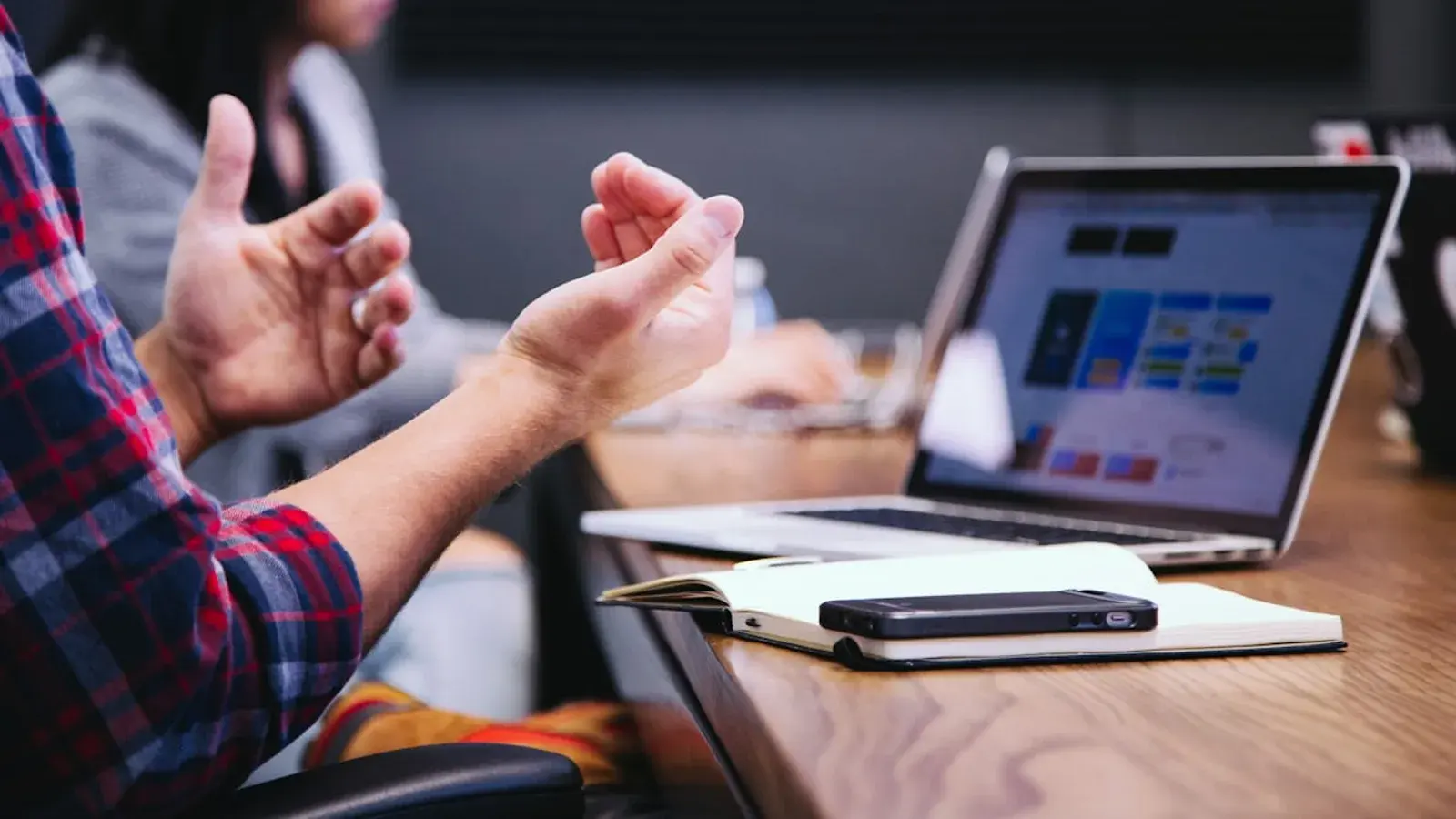 Hands clasped at a laptop showing a web page