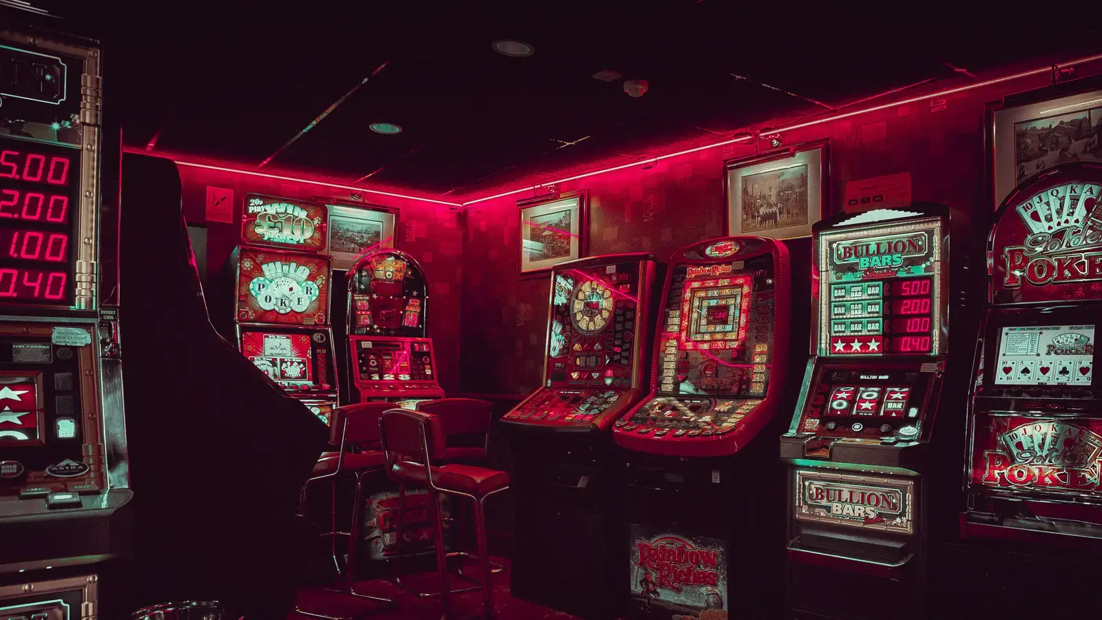 Vintage fruit machines lining a small room bathed in red light