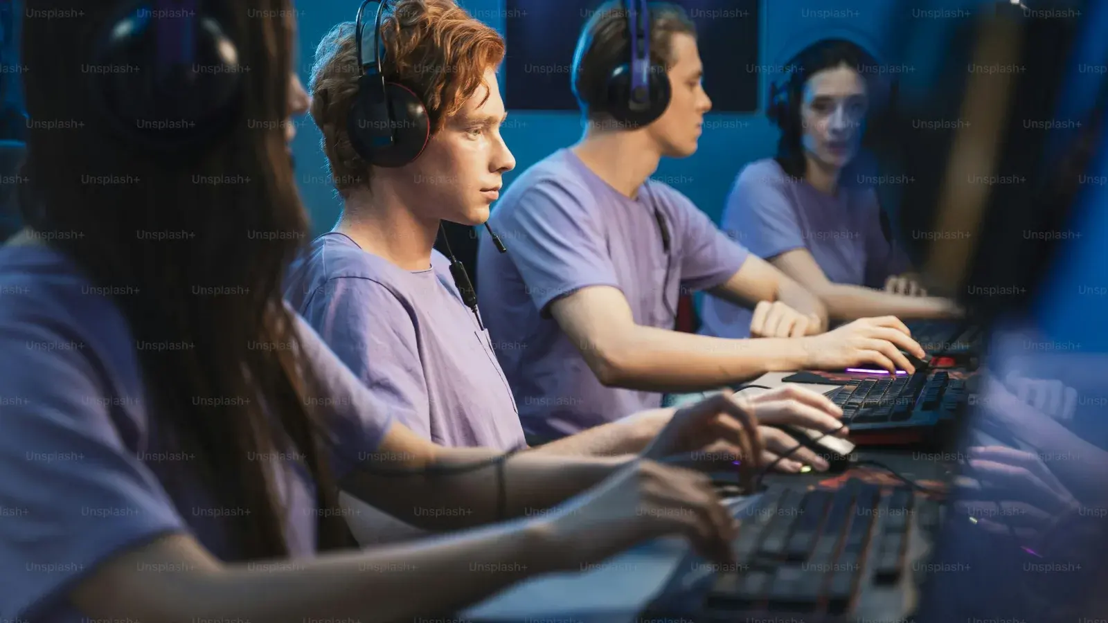 Three people in headsets typing at keyboards in daylight