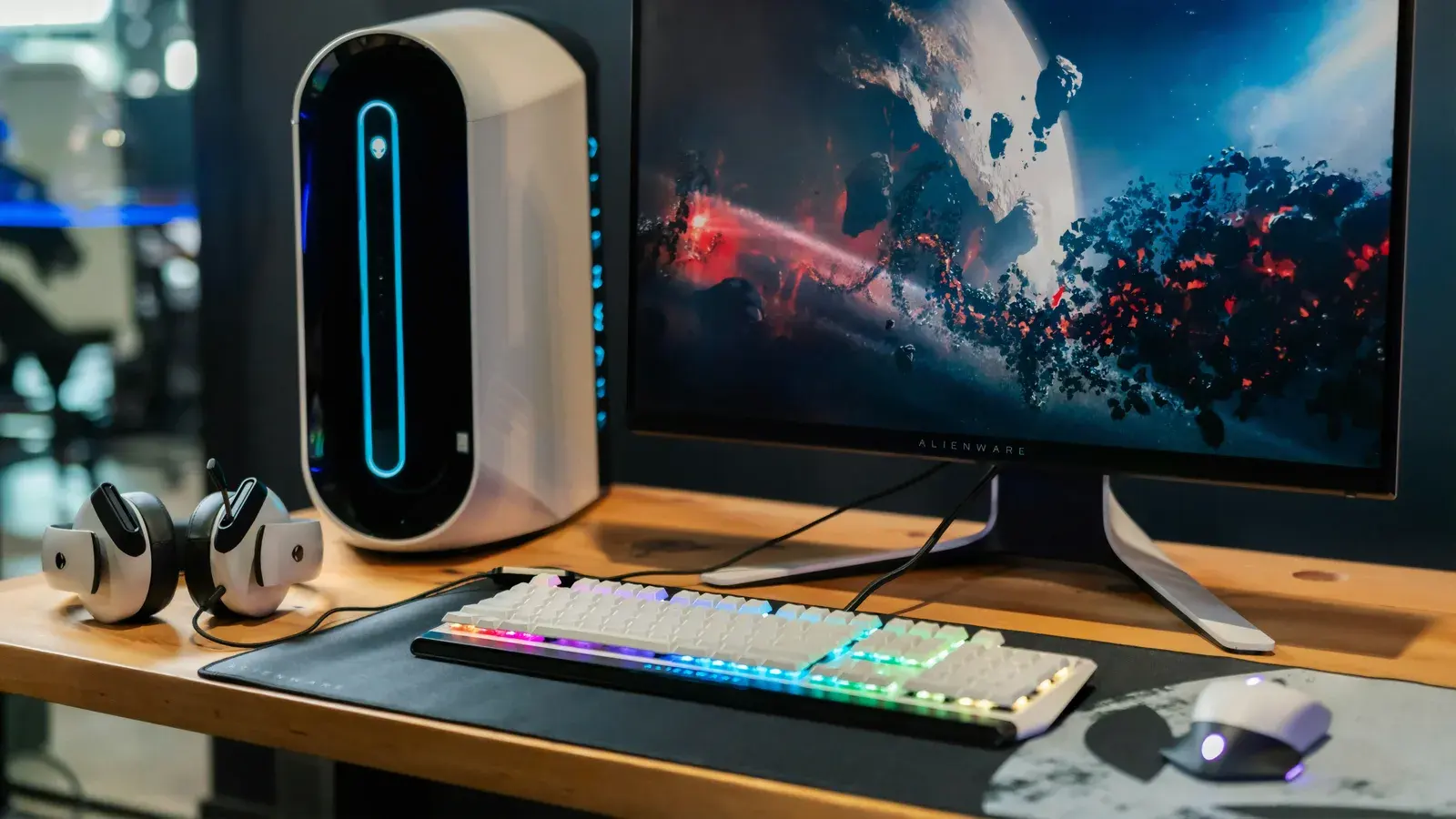 Pale desk with a monitor, headset and white PC tower