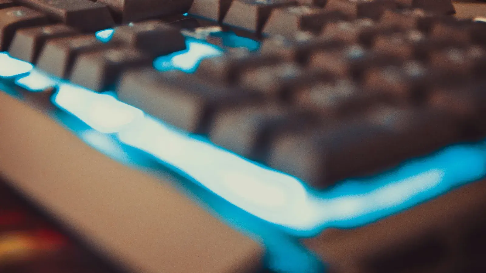 Keycaps in close focus with cyan light spilling across them
