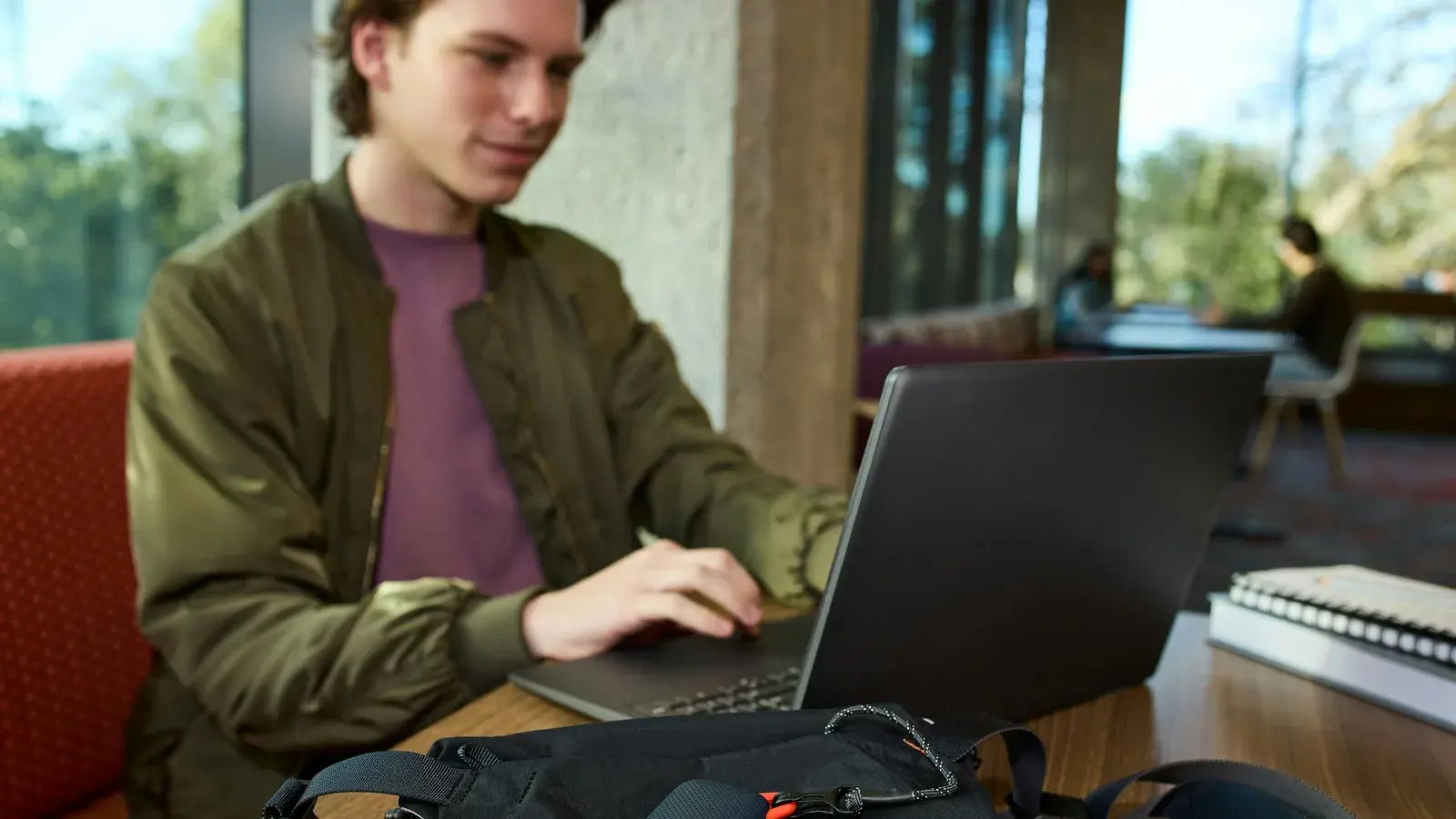 Man working on a laptop by a sunlit window