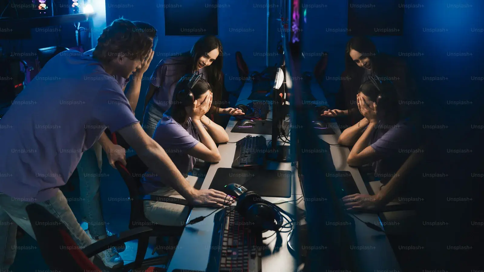 Two players at a lit gaming station mirrored down the frame