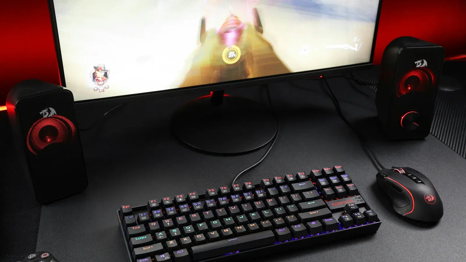 Curved monitor flanked by red speakers above a keyboard