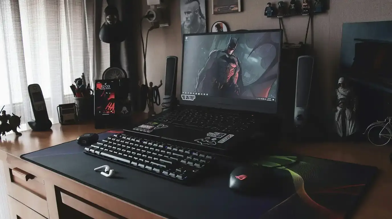 Desk with keyboard and mousepad below a monitor showing a game