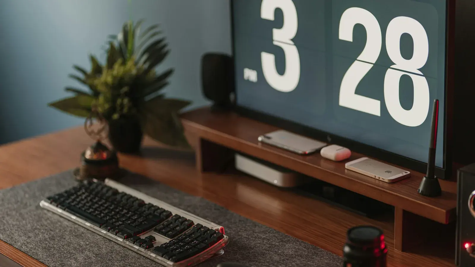 Keyboard and a flip clock reading 3:28 on a wooden shelf